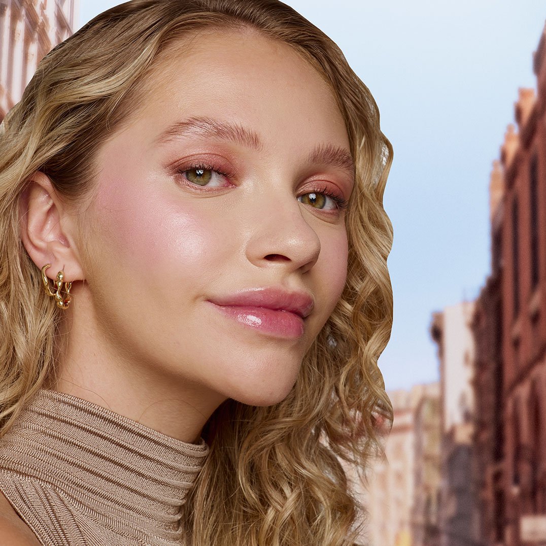 Blondynka w delikatnym makijażu rozświetlającym różem w płynie Sunkisser Blush