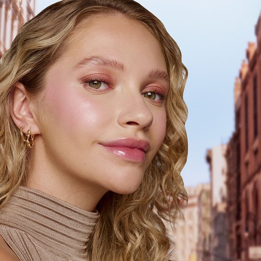 Blondynka w delikatnym makijażu rozświetlającym różem w płynie Sunkisser Blush