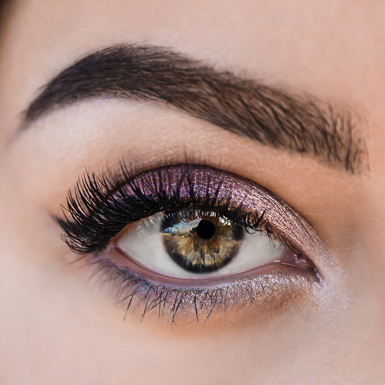 Zbliżenie na kobiece zielone oczy w fioletowym makeupie