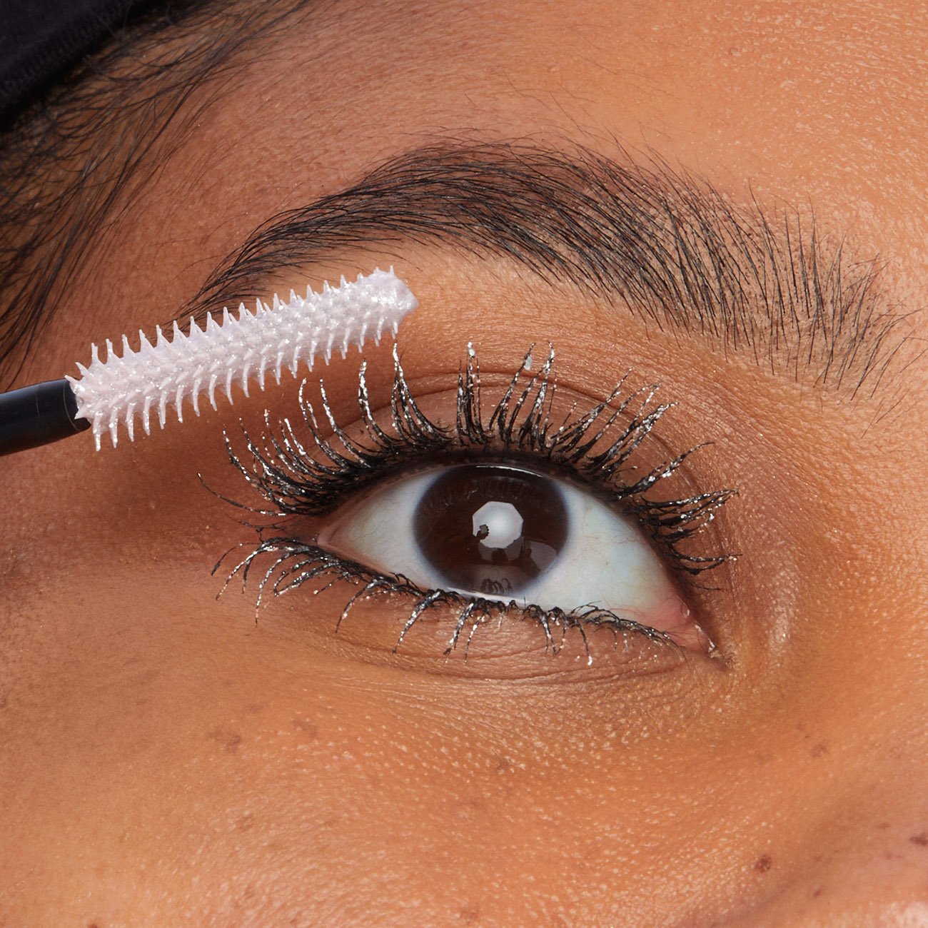 Zbliżenie na czarno-srebrny makijaż oka ze srebrnym tuszem do rzęs