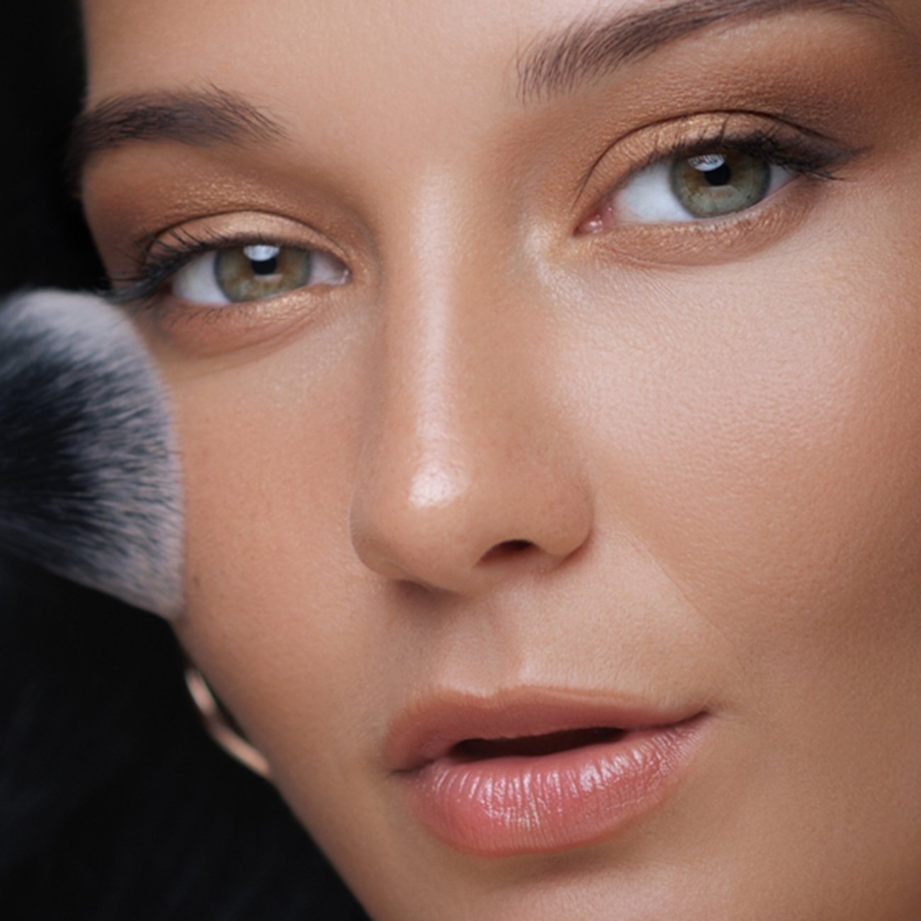 Kobieta nakładająca na twarz podkład rozświetlający