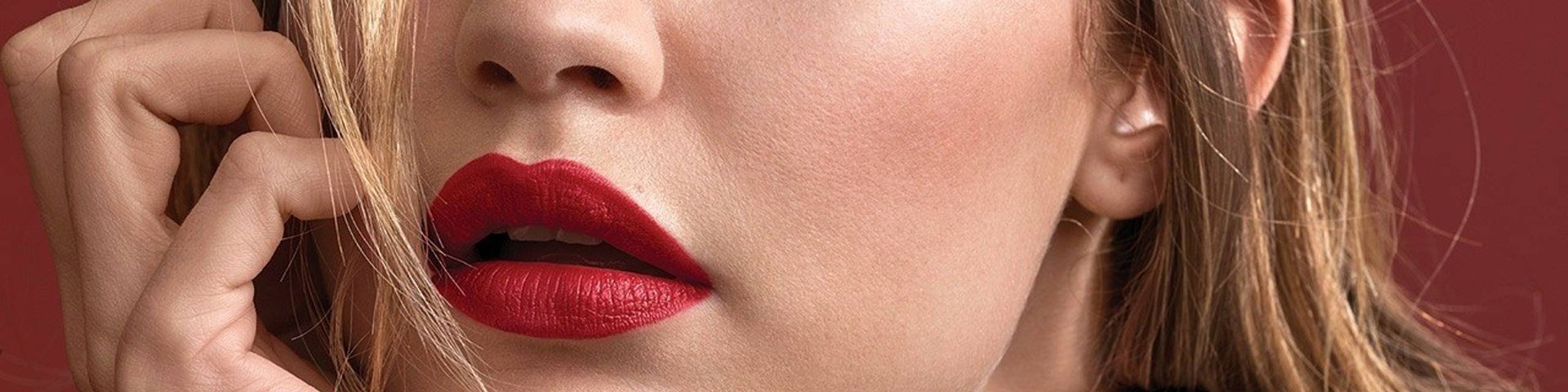 Maybelline Lipstick products illustrative banner image - Close up of woman wearing bright lipstick